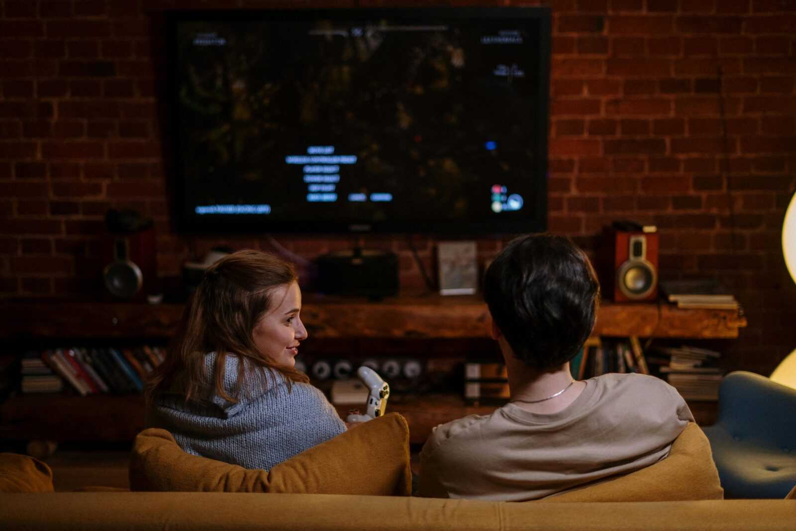 A couple enjoys a game night at home with a cozy setup and a warm atmosphere.